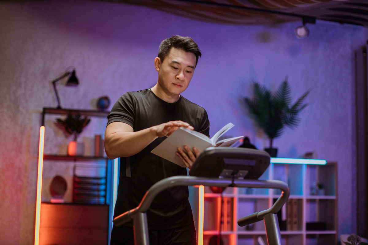 Homem Lendo um livro na esteira | Crédito: Envato Elements