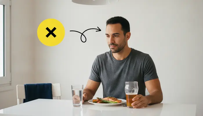 Photorealistic editorial lifestyle photograph, 16:9. A realistic adult man in his early 30s sitting at a kitchen tabl...